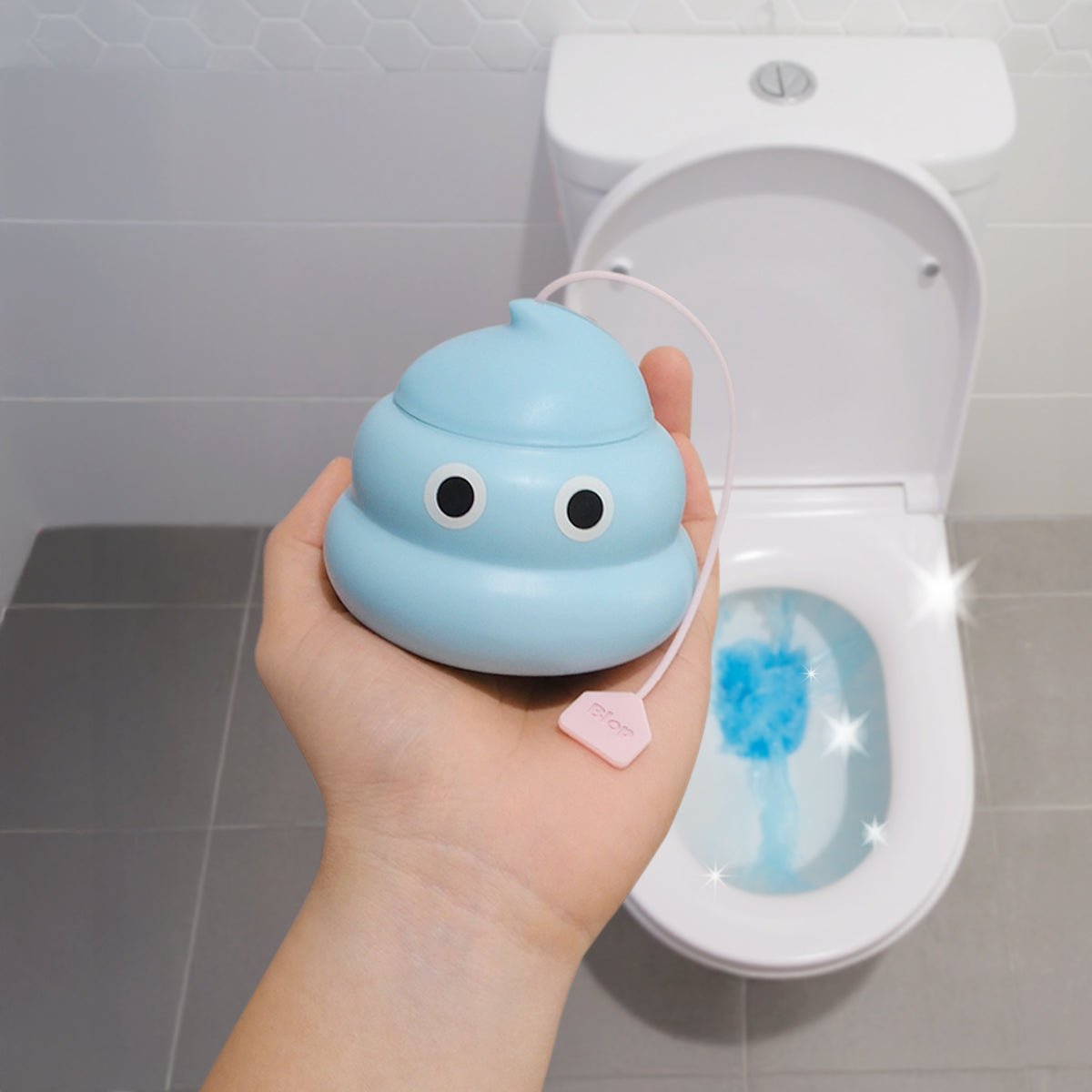 Blop automatic toilet cleaner gel held in hand next to a clean toilet bowl